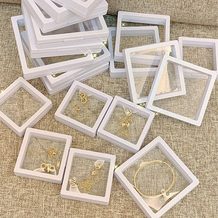 Weiße Schmuckaufbewahrungsboxen mit transparentem Deckel, ideal für Ohrringe und Armbänder.