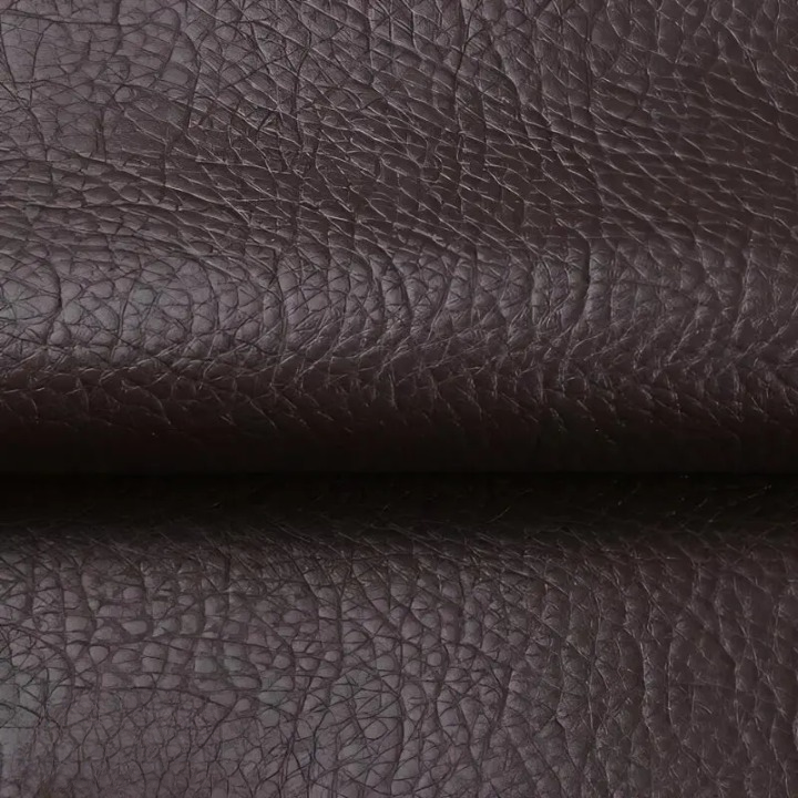 Detail tmavě hnědé zrnité textury záplaty přehnuté v záhybu 9