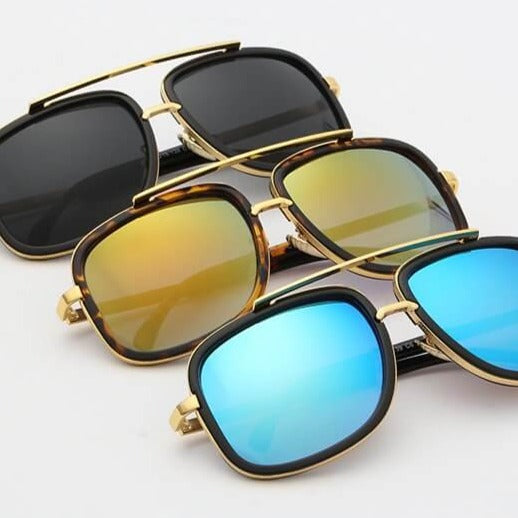 Drei Sonnenbrillen mit goldenen Rahmen und verspiegelten Gläsern in Schwarz, Gelb und Blau.