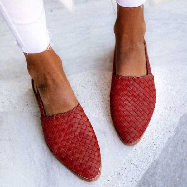 Rote geflochtene Lederslipper für Damen, modisch, bequem, auf weißem Hintergrund.