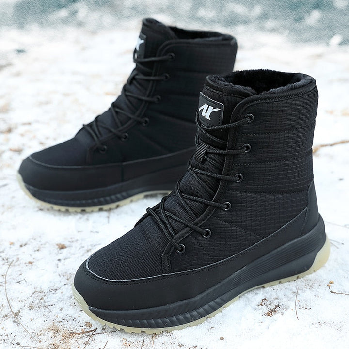 Schwarze wasserdichte Winterstiefel mit Schnürung auf Schnee, rutschfeste Sohle.
