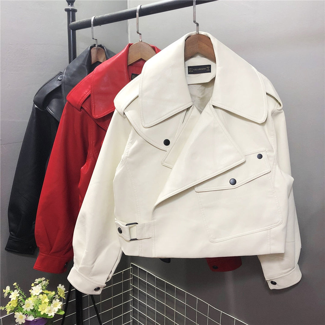 Weiße Lederjacke Damen, übergroß, mit Knöpfen, modisch, hängend auf Kleiderstange.
