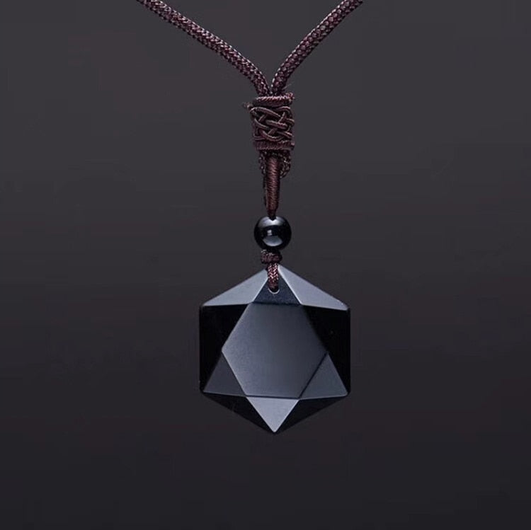 Schwarzer geometrischer Anhänger aus Onyx an braunem Lederband, eleganter Schmuck.