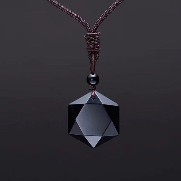Schwarzer geometrischer Anhänger aus Onyx an braunem Lederband, eleganter Schmuck.