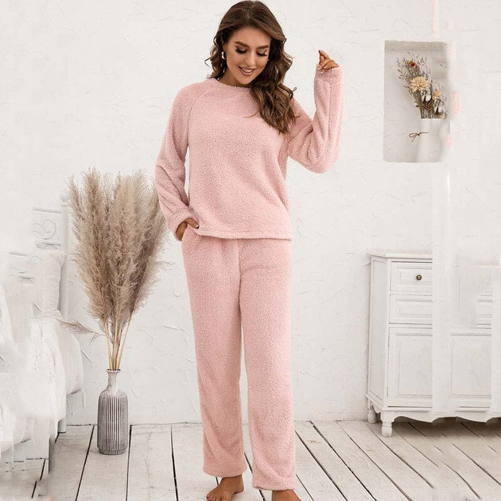Frau in rosa Fleece-Pyjama-Set, gemütlich, langärmelig, Wohnzimmer, Herbstmode.