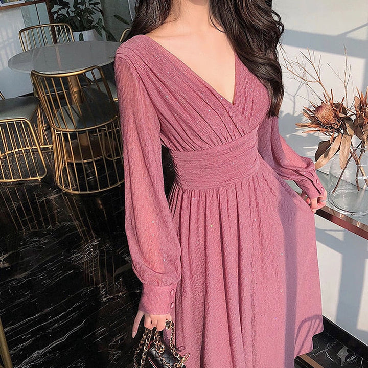 Frau in rosa Abendkleid mit V-Ausschnitt, elegantes Design, langärmlig, modisch.