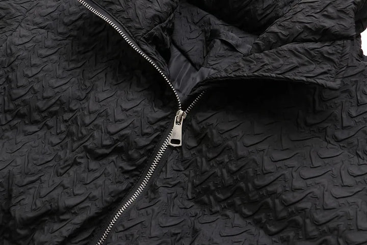 Schwarze Steppjacke mit Reißverschluss, strukturiertes Design, modische Winterbekleidung.