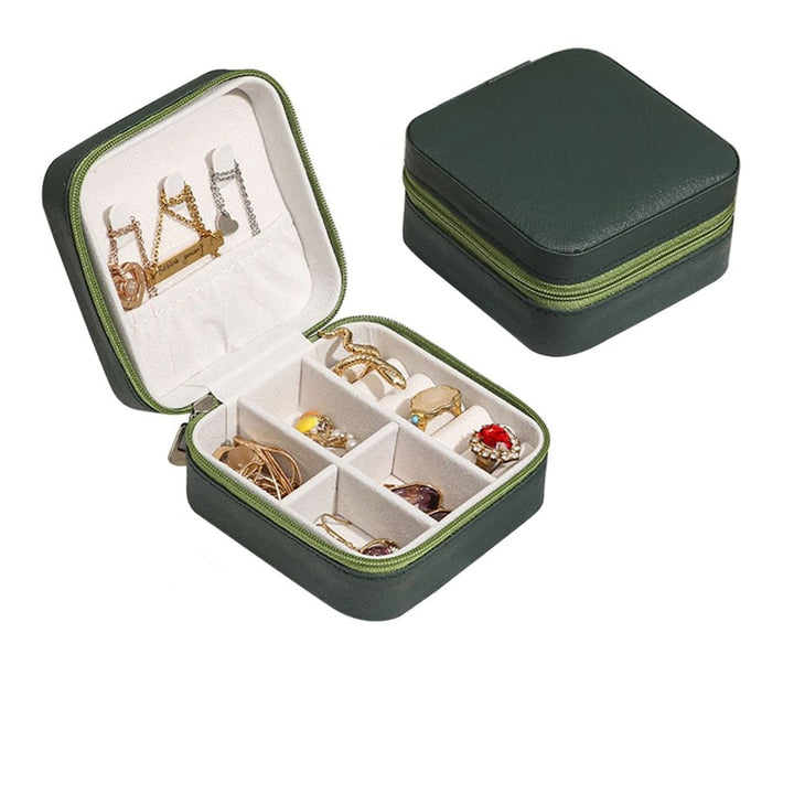 Grüne Schmuckbox aus Leder mit Fächern, ideal für Reisen, kompakt und stilvoll.