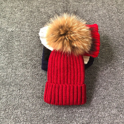 Rote Strickmütze mit Kunstfellbommel, Wintermode, warm, stilvoll, Damenaccessoire.