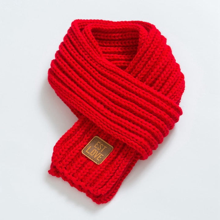Roter Strickschal aus Wolle mit Etikett, modisches Accessoire, warm und stilvoll.