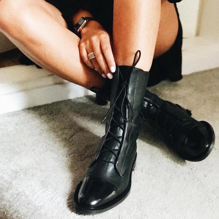 Schwarze Lederstiefel mit Schnürung, Damenmode, elegantes Design, Herbst-Winter-Trend.