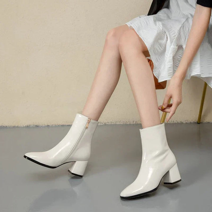 Weiße Damenstiefeletten aus Lackleder mit Blockabsatz, modisch und elegant.