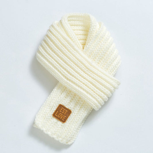 Weiße gestrickte Schal aus Wolle mit Lederetikett, modisches Winteraccessoire.