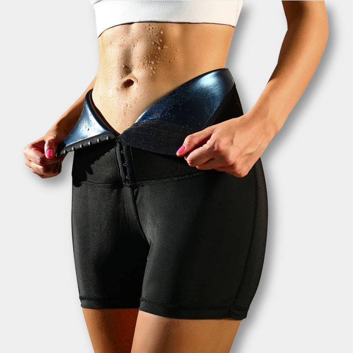 Frau in schwarzer Sauna-Sweathose mit Taillentrainer, Fitness, Fettverbrennung, Shapewear.