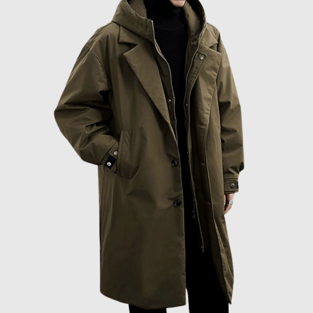 Olivově zelená dlouhá pláštěnka s kapucí na modelovi, zblízka na límec, knoflíky a zip, ruka v kapse 1