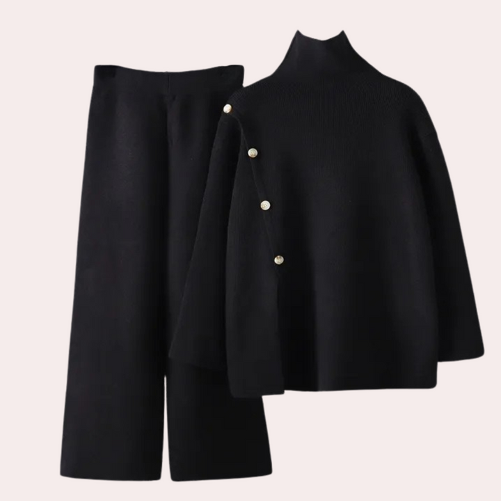 Schwarzer Damenpullover mit Perlenknöpfen und passender Hose, elegantes Winteroutfit.
