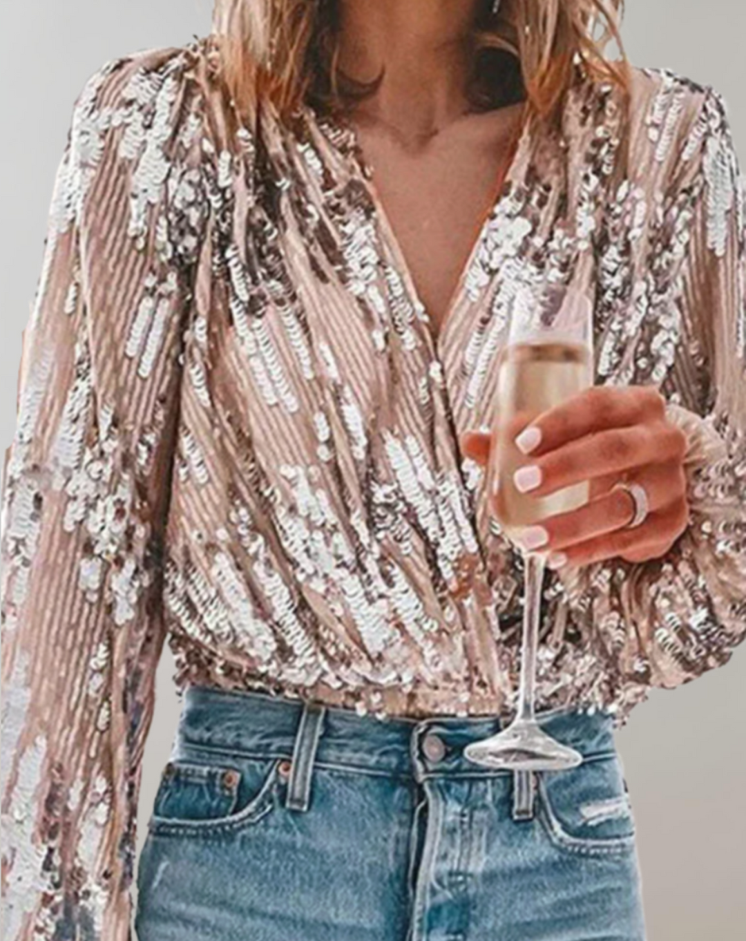 Frau in Paillettenbluse hält Champagnerglas, modisch, glamourös, Party-Outfit, Nahaufnahme.