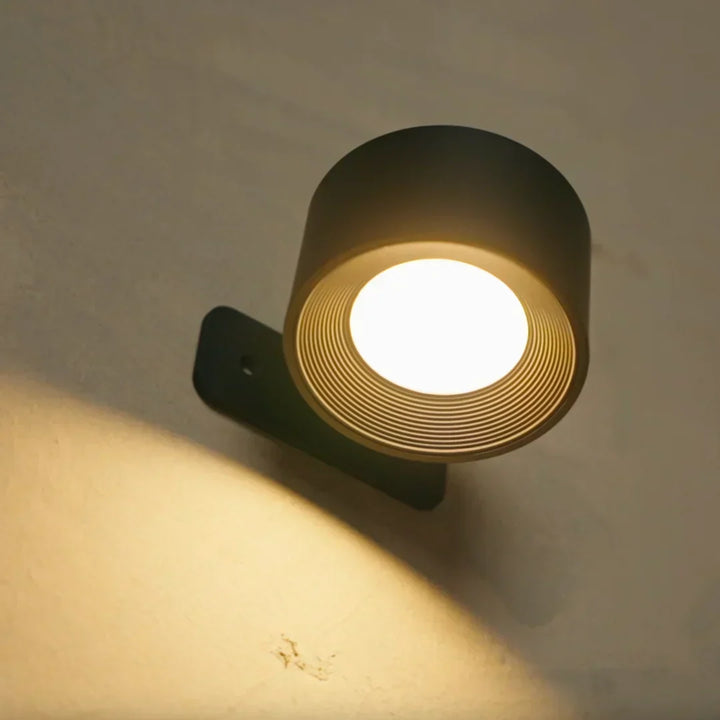 Černá lampa zespodu, rýhovaný vnitřek reflektoru a teplý kruh světla na zdi 3