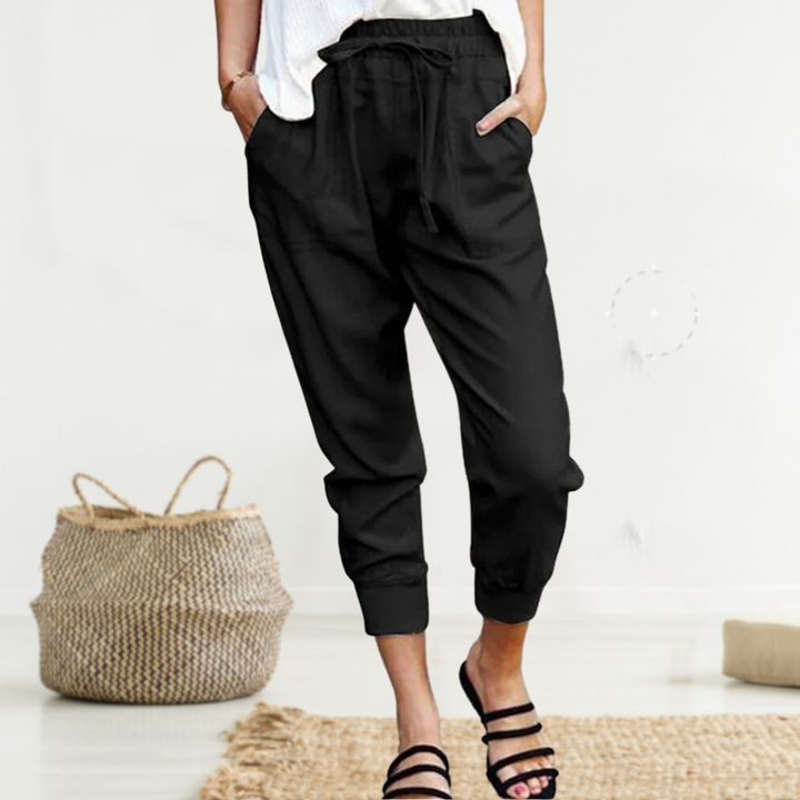 Frau trägt schwarze Leinenhose, lässig, mit Kordelzug, ideal für Sommermode, bequem.