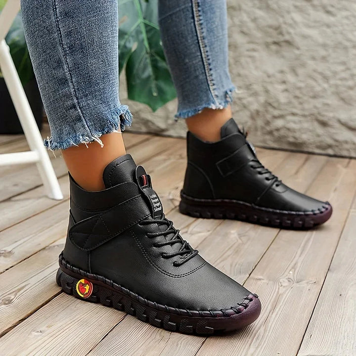 Schwarze Lederstiefel für Damen, lässig, mit Schnürung, auf Holzboden, modisch, bequem.