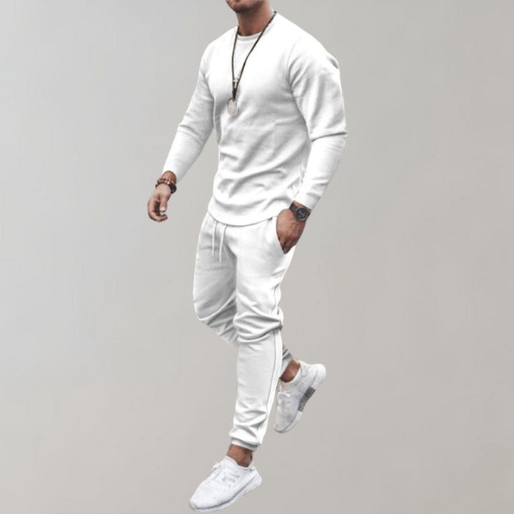 Mann in weißem Trainingsanzug, Langarmshirt, Jogginghose, Sneakers, sportlich, modern.
