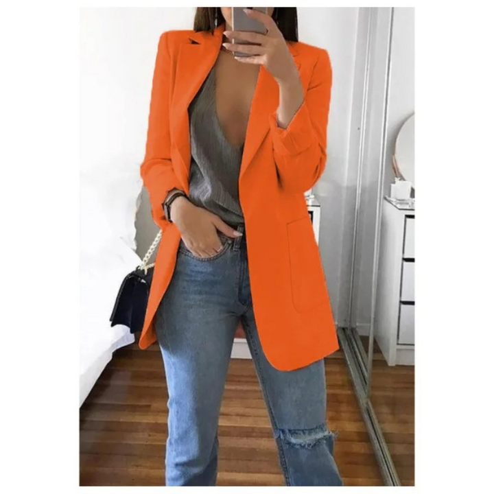 Frau in orangefarbenem Blazer, grauem Top und Jeans, modisch, elegant, Damenmode.