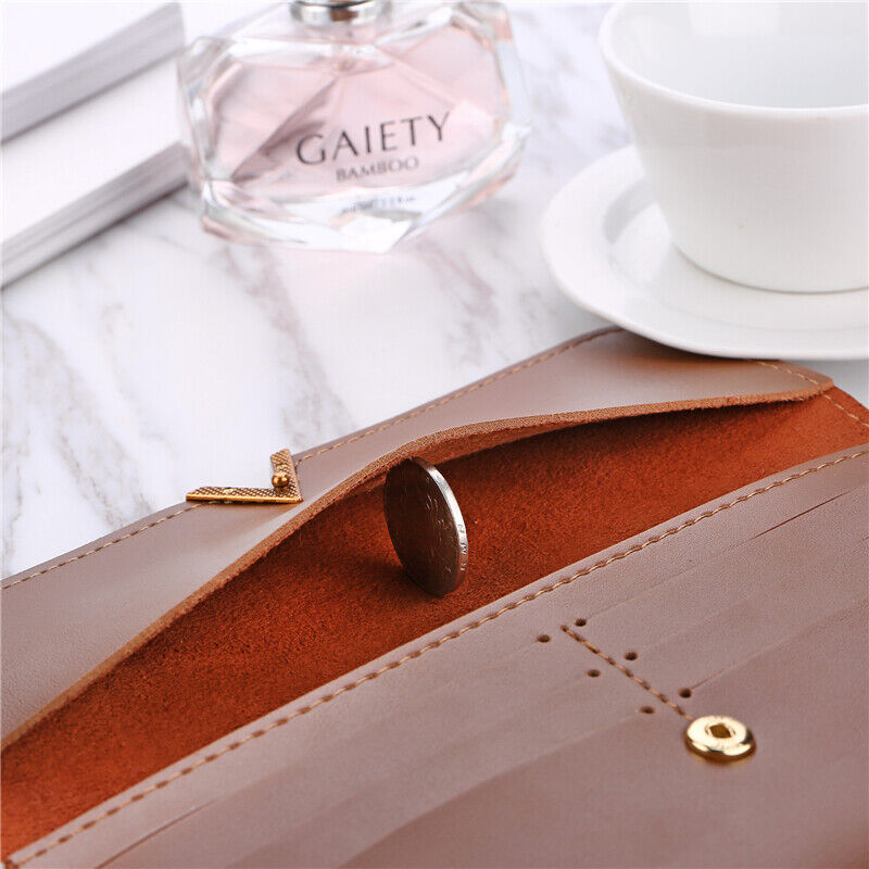 Braune Lederbrieftasche mit Münzfach, elegantes Design, auf Marmortisch, neben Parfümflasche.