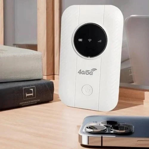 Bílý router opřený o knihy na dřevěném stole vedle telefonu 3