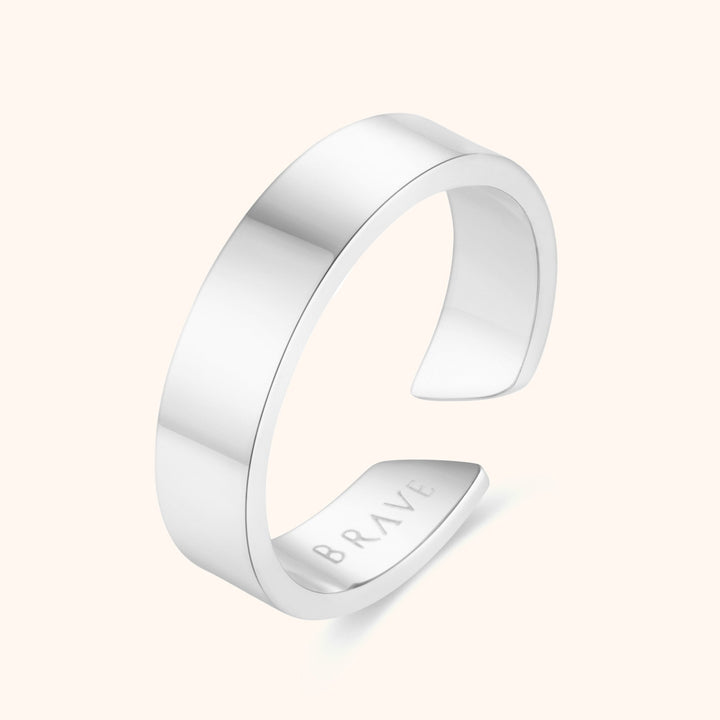 Silberner offener Ring aus Edelstahl mit Gravur "BRAVE", minimalistisches Design.
