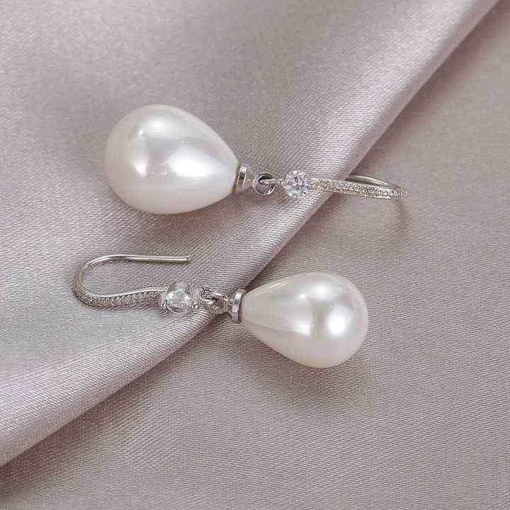 Perlenohrringe mit Tropfenform, Silberhaken, funkelnde Kristalle, eleganter Schmuck.