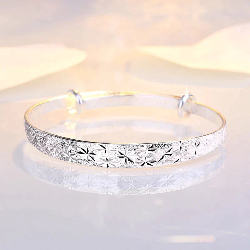 Silberarmreif mit Blumenmuster, elegantes Schmuckdesign, glänzend, für Damen.