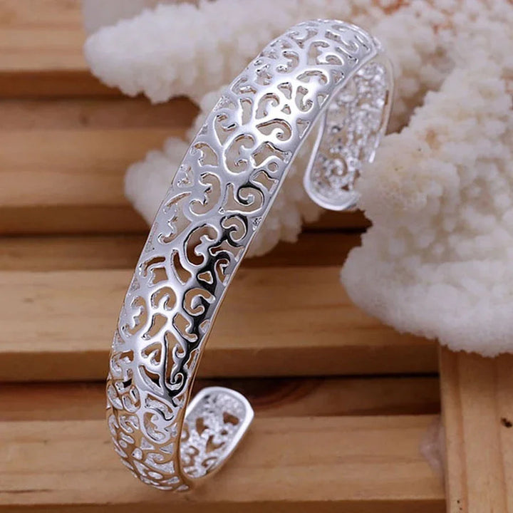 Silberarmreif mit filigranem Muster, elegantes Schmuckstück, Damenaccessoire, Geschenkidee.