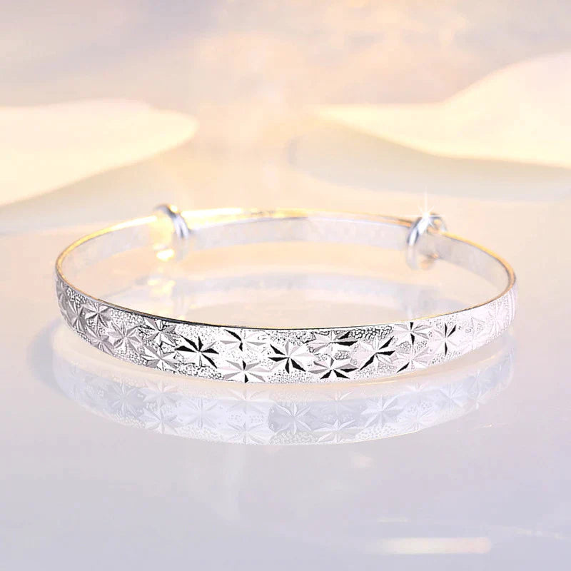 Silberarmreif mit Blumenmuster, glänzend, elegant, Schmuck für Damen, modisch, Accessoire.