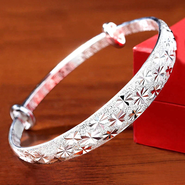 Silberarmreif mit Sternmuster, glänzend, elegantes Schmuckstück, Geschenkidee, Damenarmband.