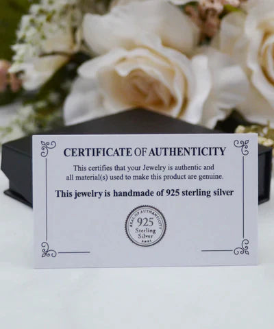 Echtheitszertifikat für handgefertigten 925er Sterlingsilber Schmuck vor Blumenhintergrund.