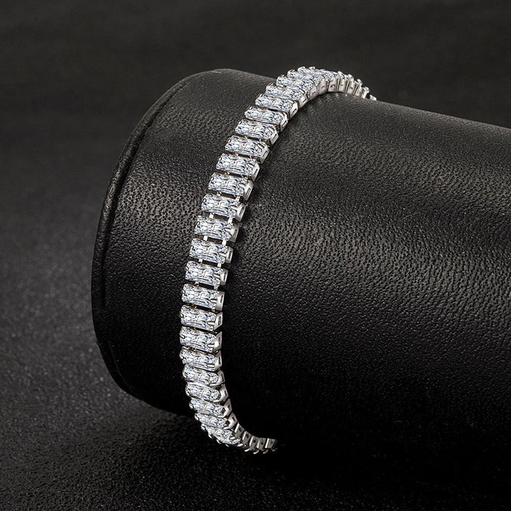 Silbernes Tennisarmband mit rechteckigen Zirkonia-Steinen auf schwarzem Hintergrund.