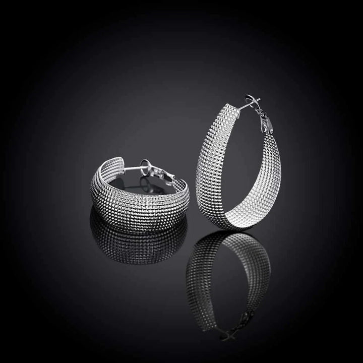 Silberne Creolen Ohrringe, strukturiertes Design, Schmuck für Damen, modisch, elegant.