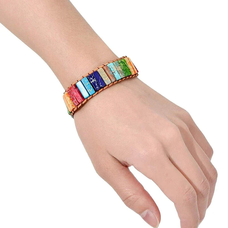 Buntes Armband aus Natursteinen auf Handgelenk, handgefertigt, modisches Accessoire.