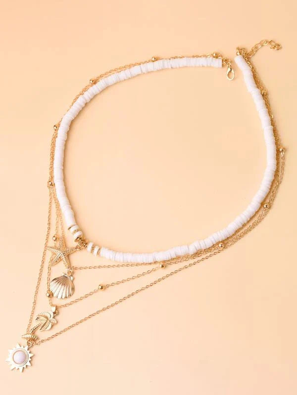 Goldene Halskette mit Muschel- und Sonnenanhängern, mehrlagig, Damenmode, Schmuckaccessoire.