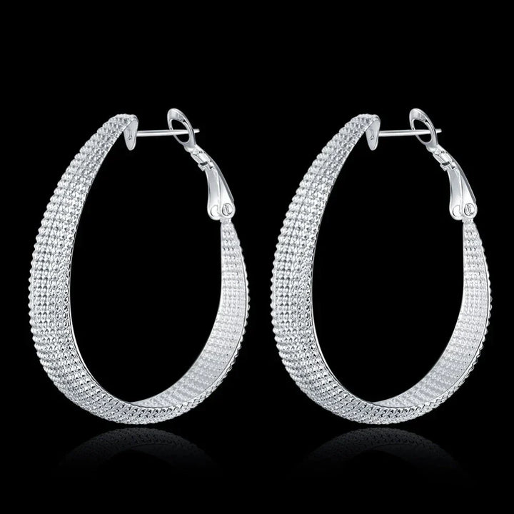 Silberne Creolen Ohrringe, strukturiertes Design, eleganter Schmuck, Damen Accessoire.