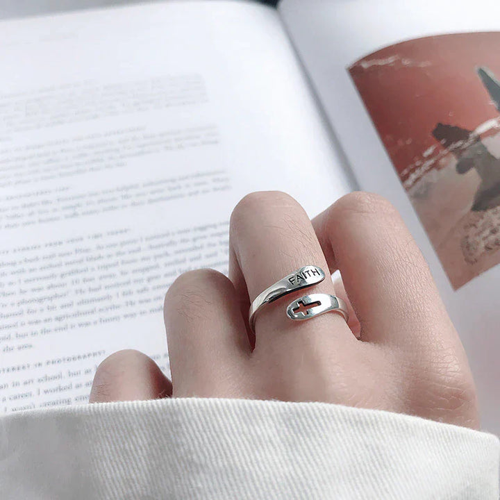 Silberner Ring mit Kreuz und "Faith"-Gravur auf Hand, modisches Accessoire, religiöser Schmuck.
