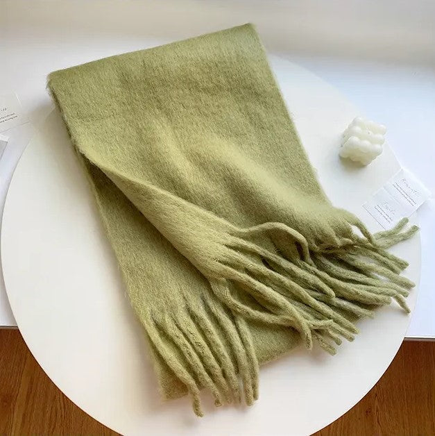 Grüner Wollschal mit Fransen, weiches Material, modisches Accessoire, Herbst-Winter-Mode.