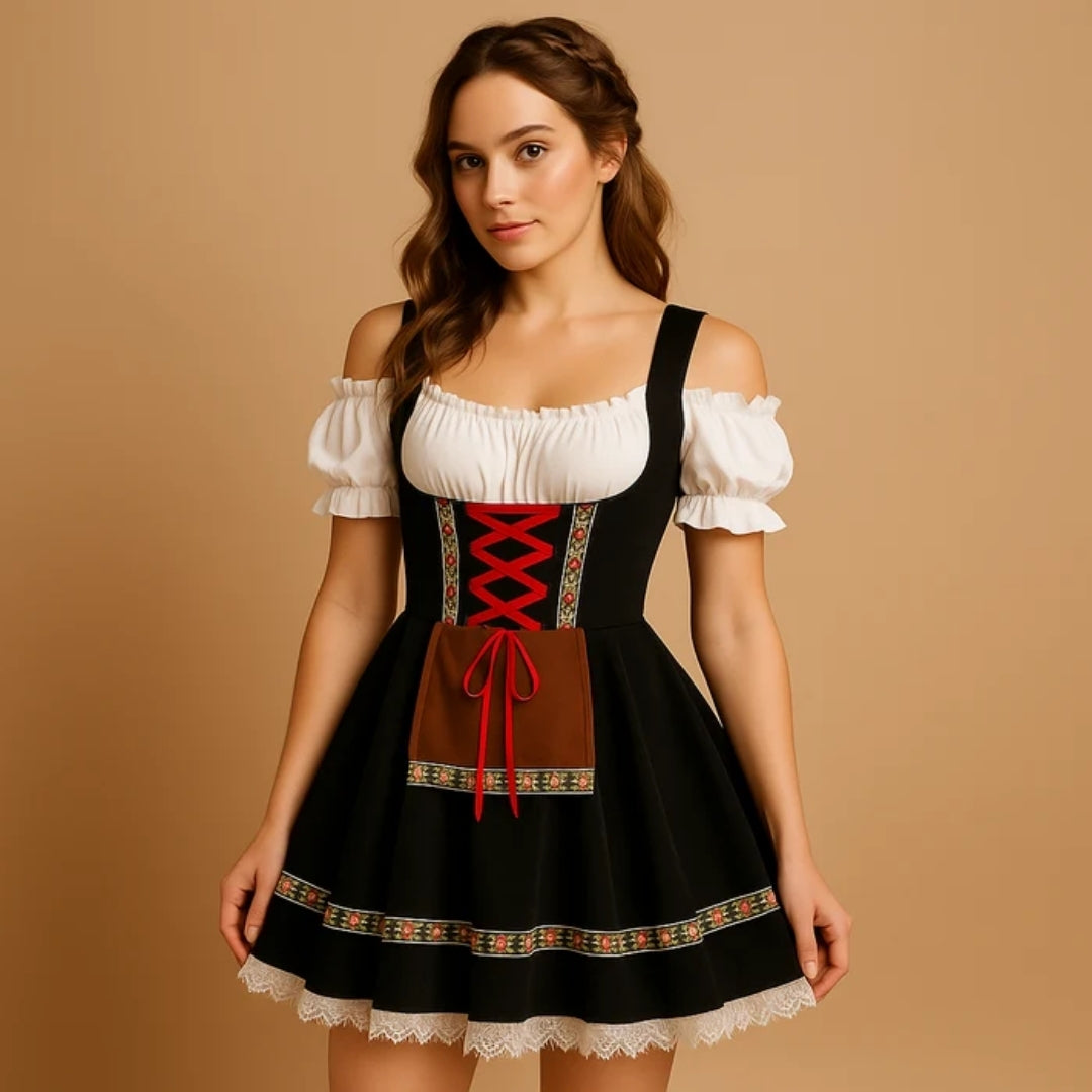 Modelka v černých dirndl šatech s červeným šněrováním, hnědou kapsou, květovanou stuhou na sukni, bílým krajkovým lemem a copánkem ve vlasech. 7