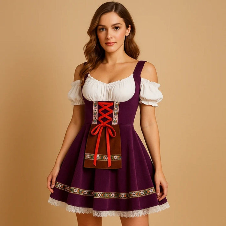 Modelka ve fialových dirndl šatech s odhalenými rameny, červeným šněrováním, hnědou kapsou se vzorovanou stuhou a krajkovým lemem sukně. 2