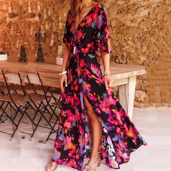 Frau in bunter Maxi-Wickelkleid, Blumenmuster, vor rustikalem Holztisch, Sommermode.