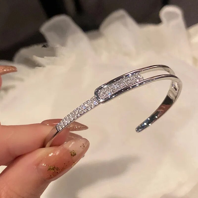 Silbernes Armband mit Strasssteinen, elegantes Design, Schmuck für Damen, modisch und glänzend.