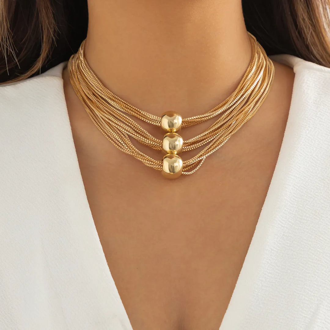 Goldene Halskette mit mehreren Strängen und Kugeln, elegantes Schmuckdesign für Damen.