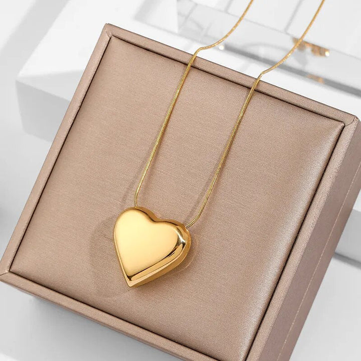 Goldenes Herz-Halskette auf beigem Schmuckkästchen, elegantes Design, Geschenkidee.