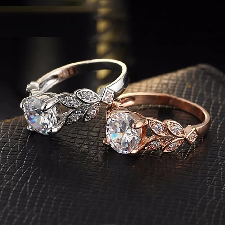 Zwei elegante Verlobungsringe, Silber und Roségold, mit Zirkonia-Steinen auf schwarzem Hintergrund.