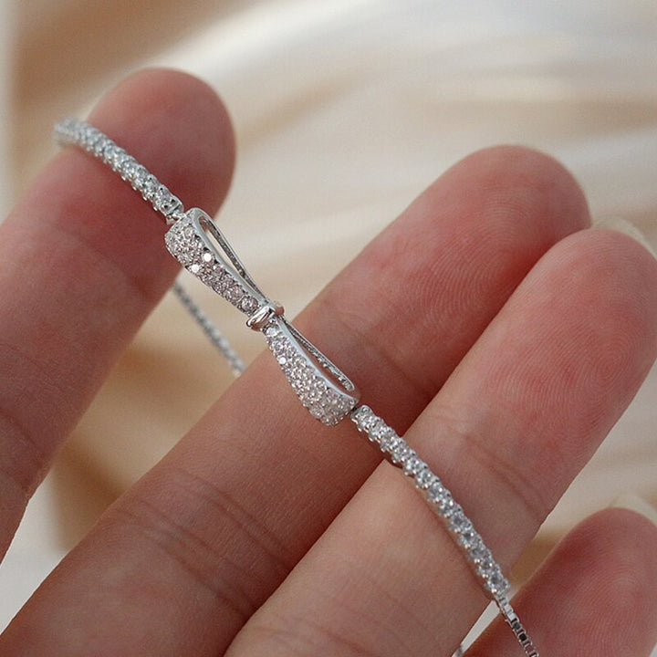 Silbernes Armband mit Schleife, Zirkonia-Steinen, elegantes Schmuckdesign, Nahaufnahme.